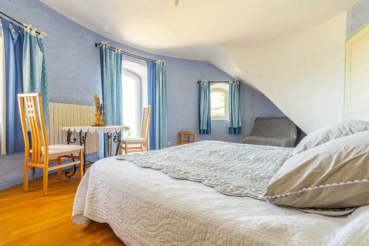 Chambre d'hôtes spacieuse avec lit double au Château de la Gabelle en Drôme provençale, décorée en tons bleus avec coin salon.