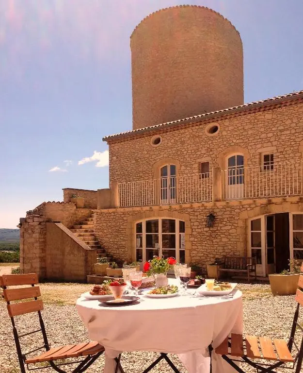 Repas en extérieur à la table d'hôtes du Château de la Gabelle avec vue sur la tour en pierre